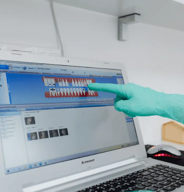 Two people sitting at a table looking at a laptop.